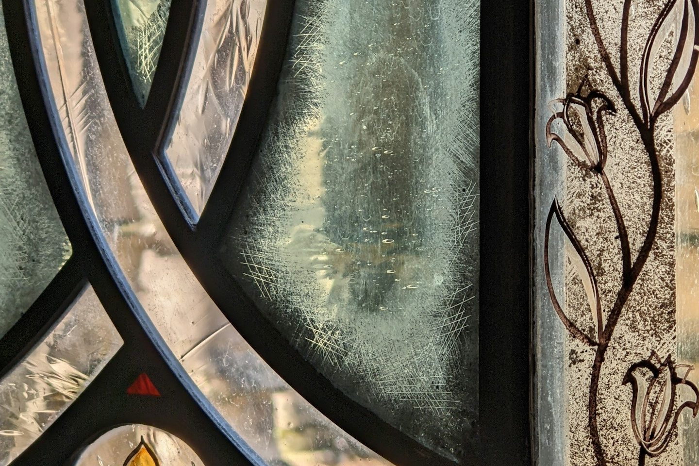 Buntes Glasfenster mit floralen Mustern.