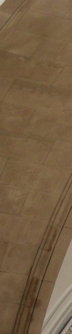 Braune Decke aus Stein mit sanften, geschwungenen Linien und Texturen.